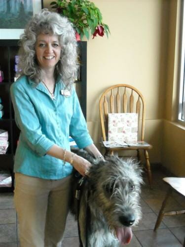 Large long haired dog standing next to female